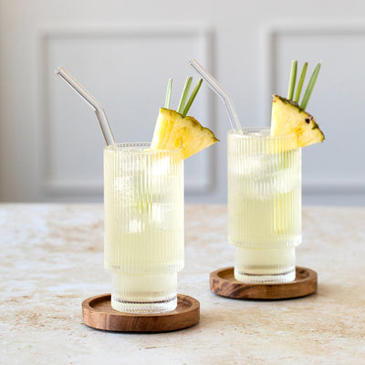 Two glasses of Tea-ki and Tonic beverages with pineapple wedge and lemongrass garnish.
