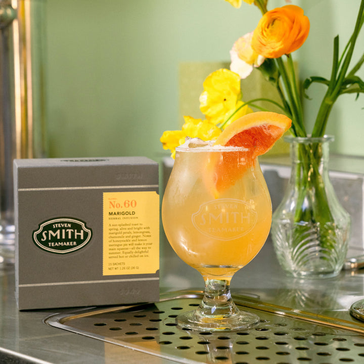 Golden hour with a slice of grapefruit in front of a vase of flowers