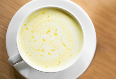 Top down of Golden Light latte in teacup with lemon zest.