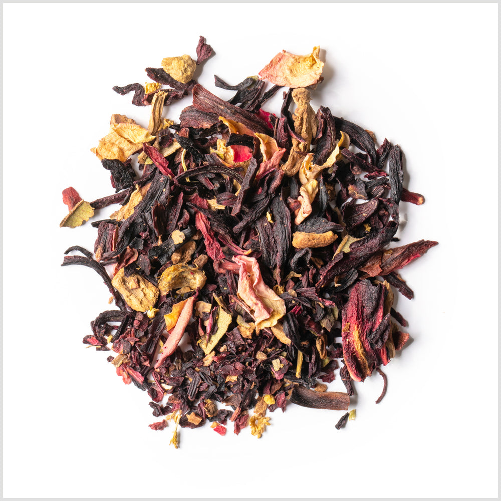 Circular pile of hibiscus petals, ginger and pink rose petals on white background.