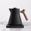 Black electric tea kettle with maple wooden handle.
