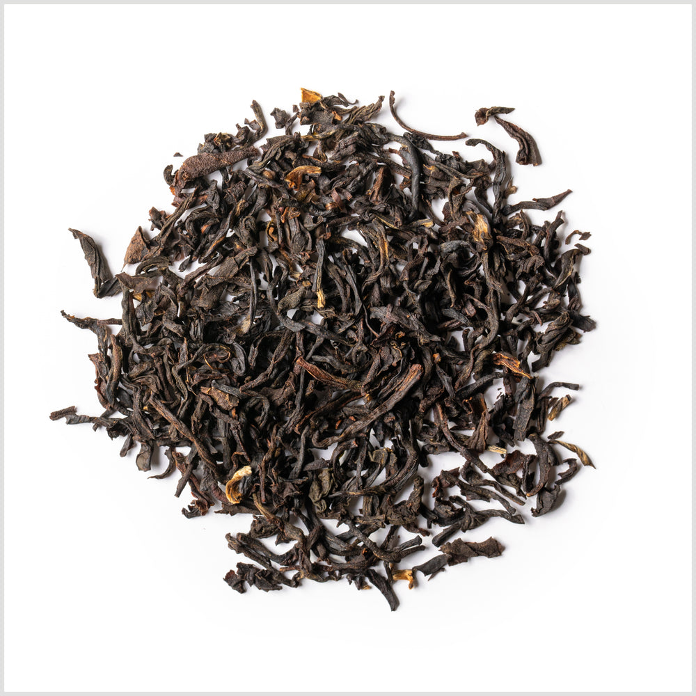 A small pile of full leaf Lord Bergamot black tea on a white background.