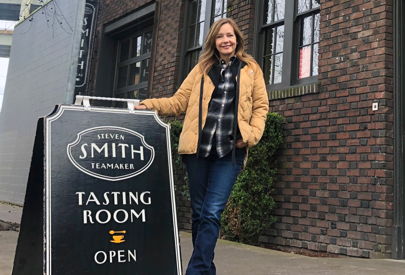 Smith Teamaker co-founder, Kim Dement, standing proudly in front of the first Smith Tasting Room.