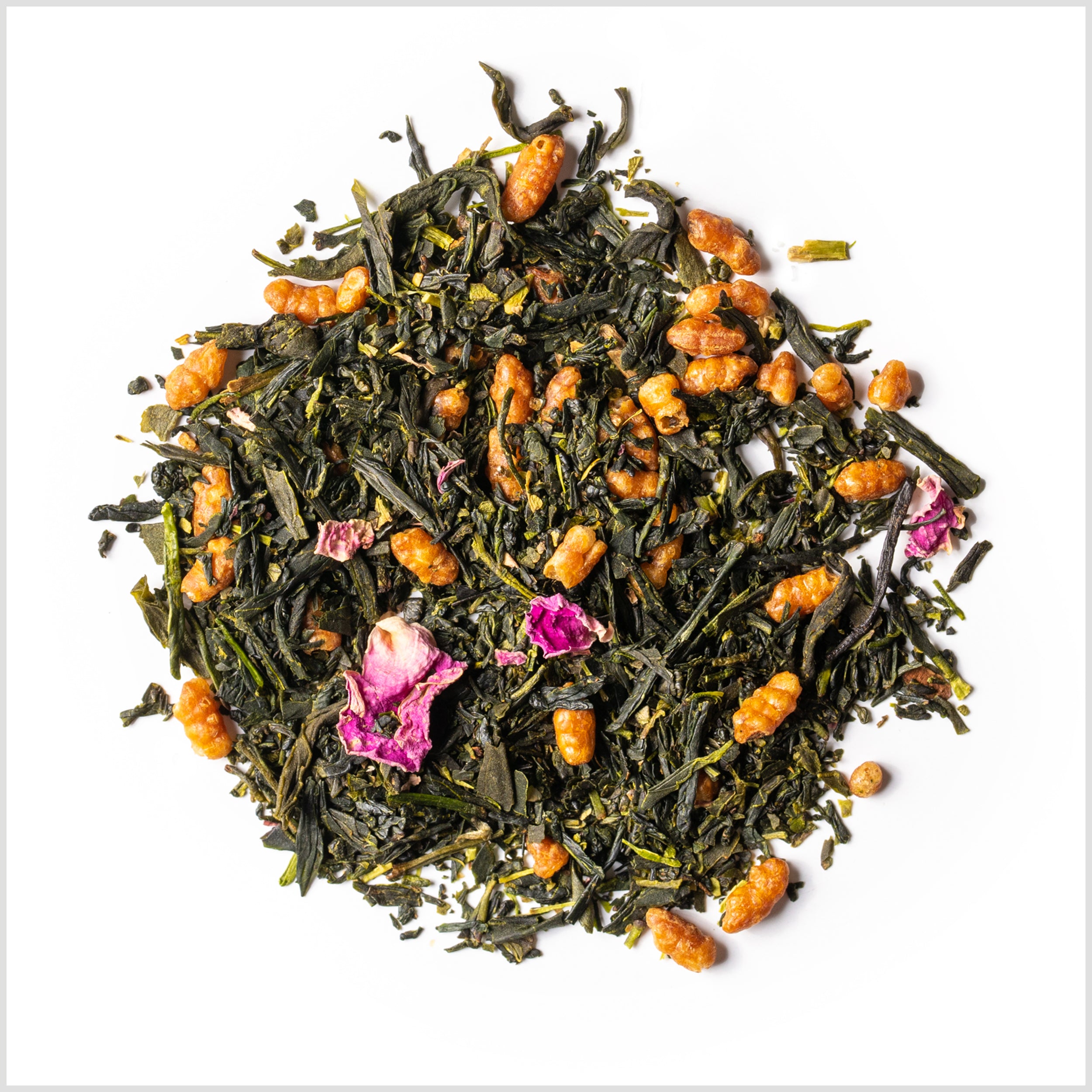 Circular pile of sencha full leaf tea with toasted genmai rice and pink rose petals.