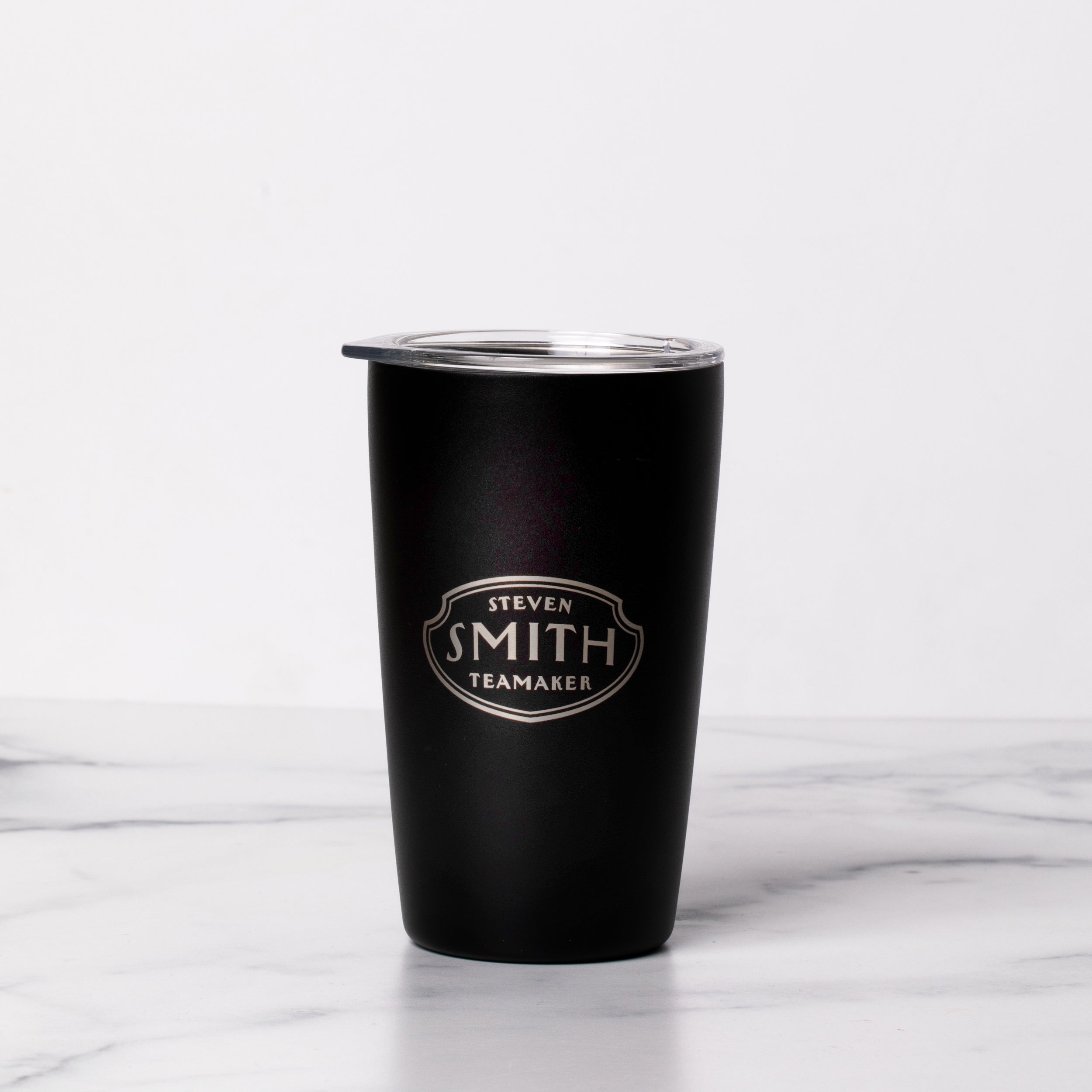 Black to-go tumbler with silver etched Smith logo shield and clear top.
