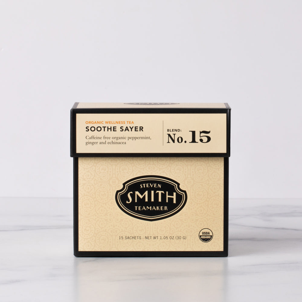 Cream box of Soothe Sayer organic wellness tea on marble table.