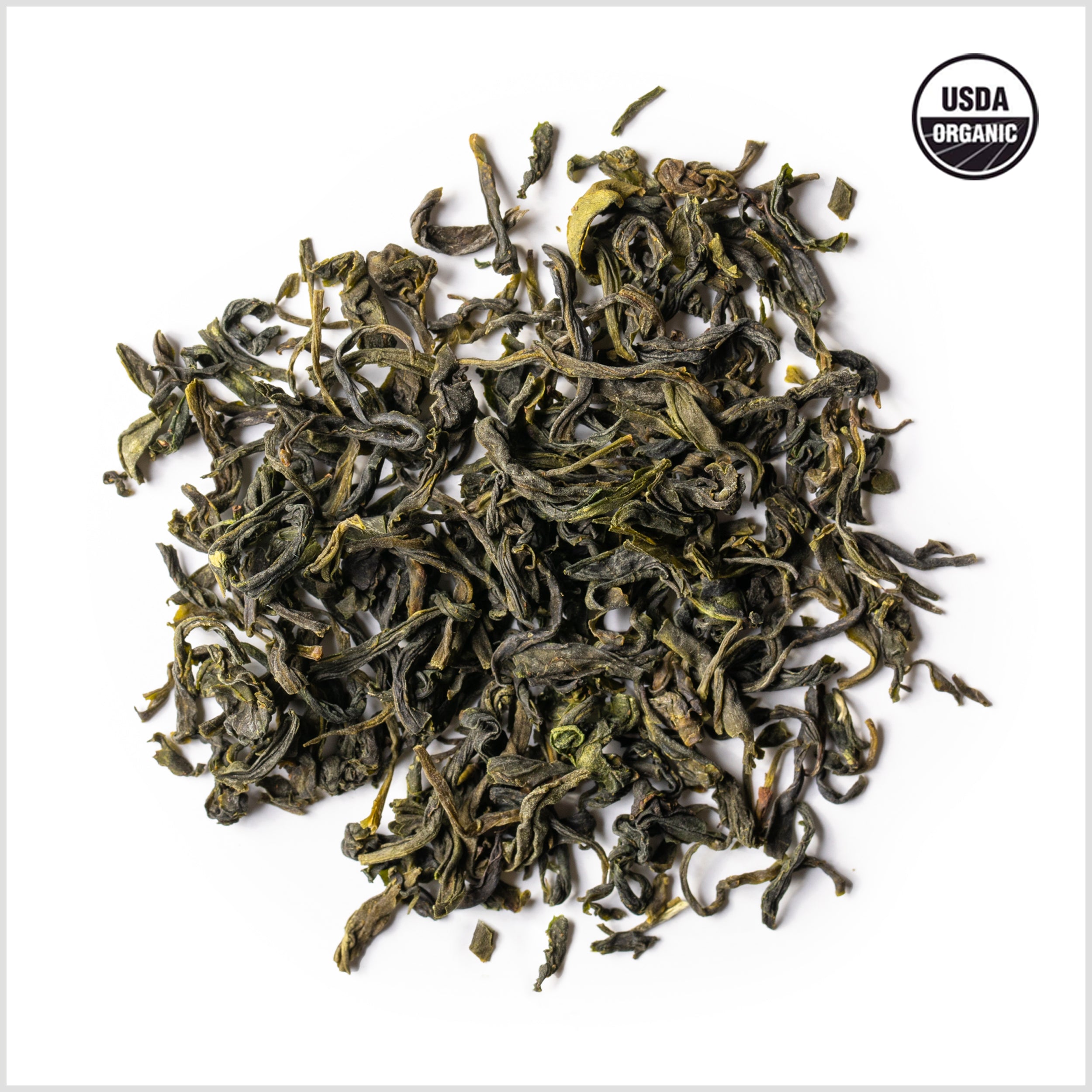 Circular pile of full leaf organic green tea.