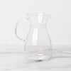 Empty glass decanter with spout on marble background.