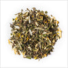 Circular pile of Bai Mu Dan white tea with chamomile petals, osmanthus and other ingredients.