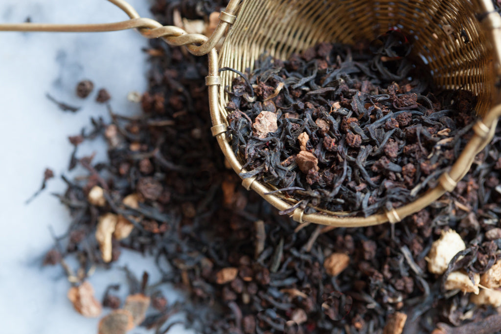 Up close view of Masala Chai tea to show black tea leaves, black peppercorns and spices.