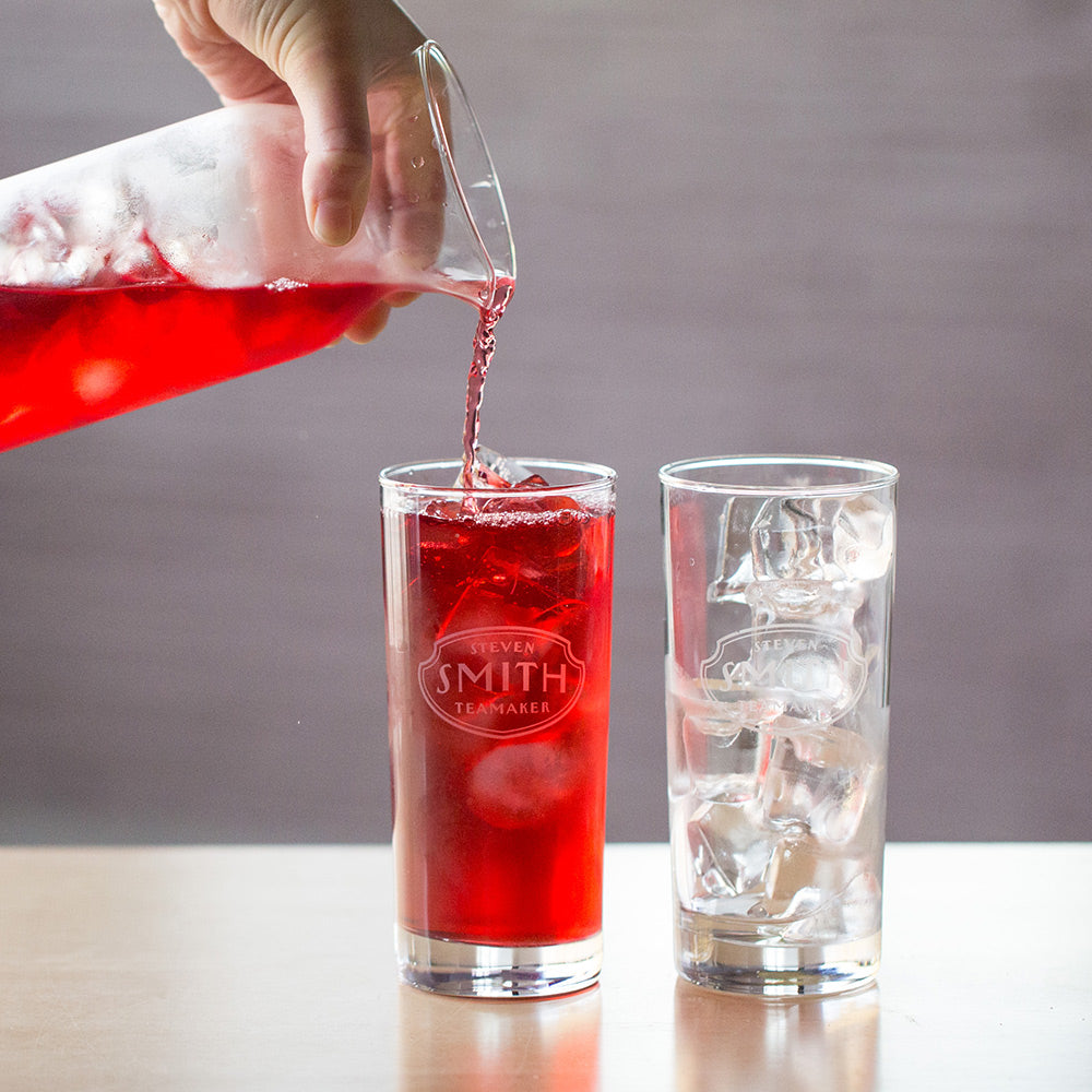 Tall collins glass branded with Smith logo shield filled with red iced tea.