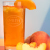 Glass of Ginger Peach iced tea with slice of peach.
