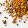Pile of loose dried turmeric, black pepper and sarsaparilla on marble background.