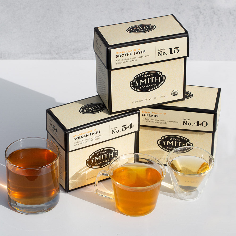 Three cream cartons of tea in different flavors on top of a white background.
