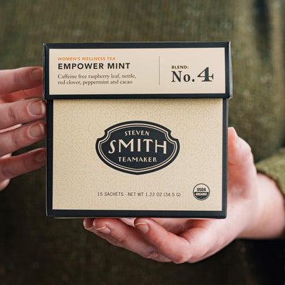 Person holding cream box of Empower Mint wellness blend.