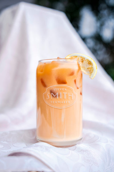 Smith branded glass of Meet Cute Milk Tea with a candied lemon wedge for garnish.