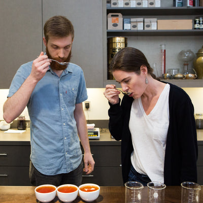 Teamakers tasting tea with spoons in the tea lab at Smith Teamaker in Portland, Oregon.