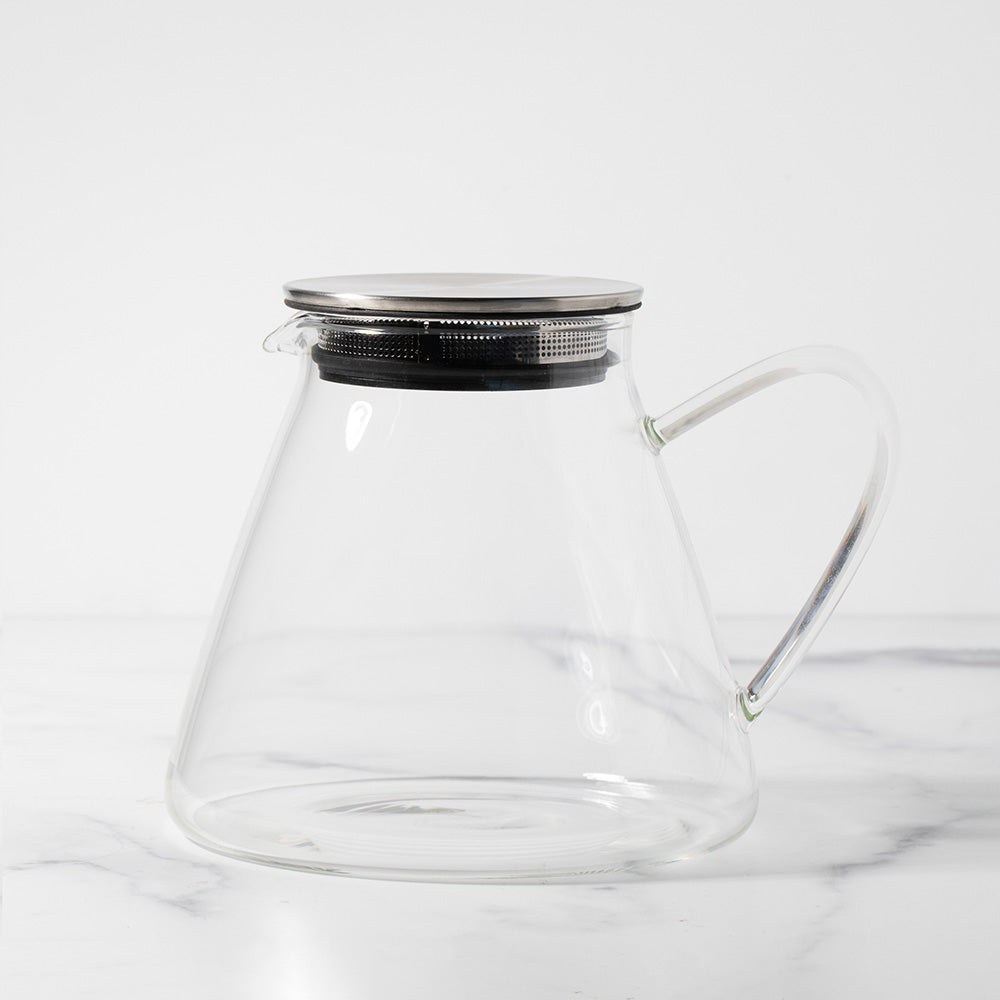 Empty glass pitcher with a silver lid.