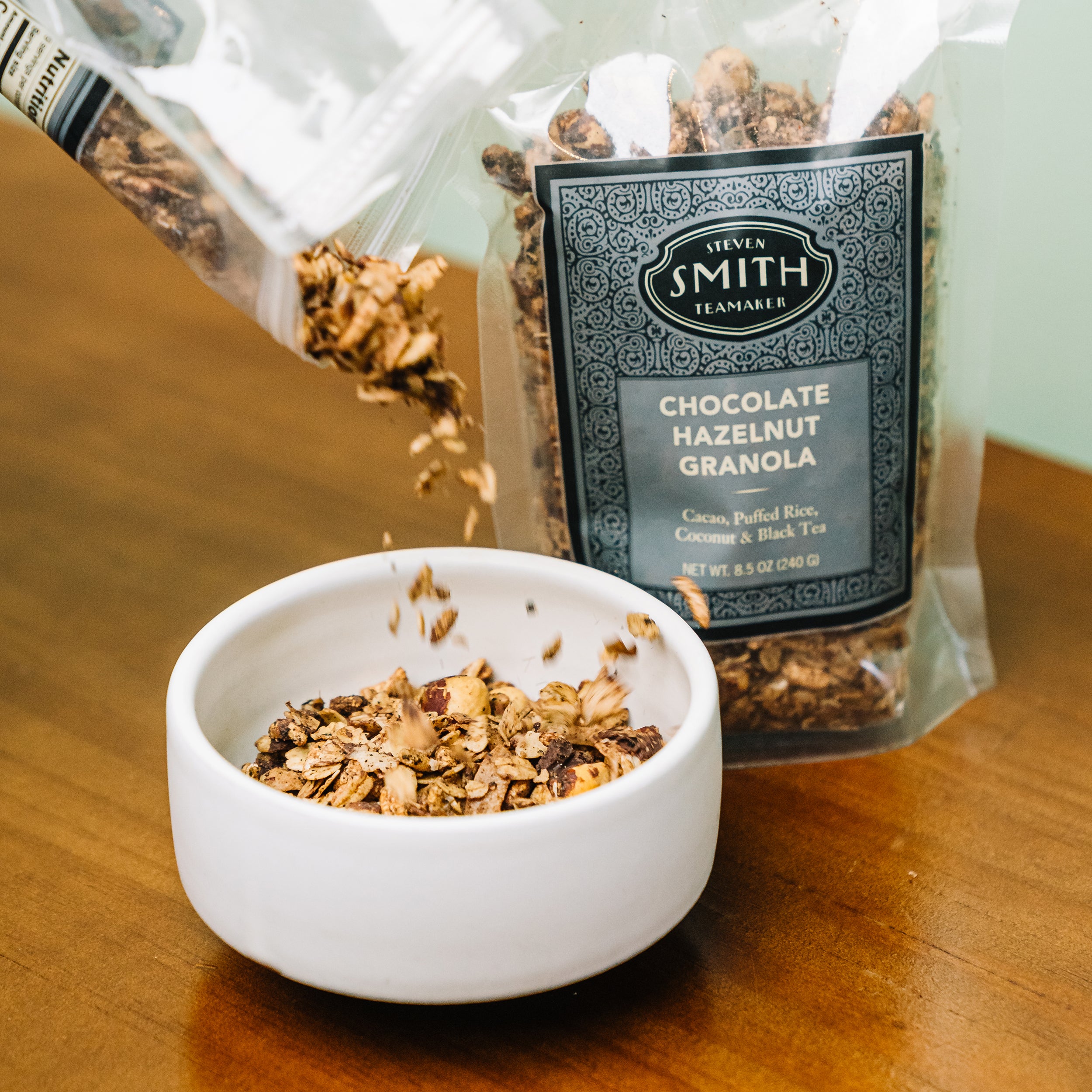 White bowl filled with granola on wooden table.