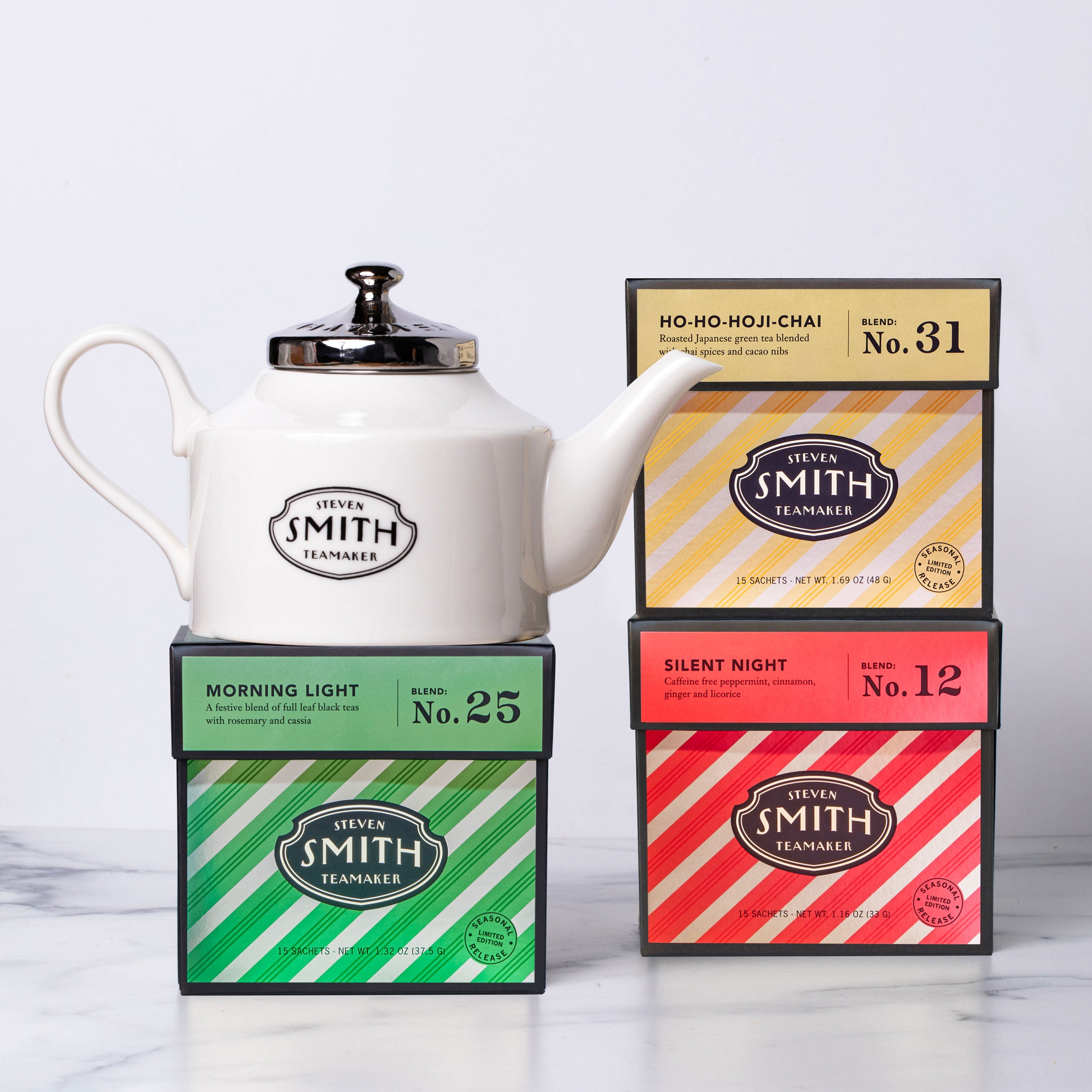 White teapot with 'Smith Tea' and three holiday cartons on a white background