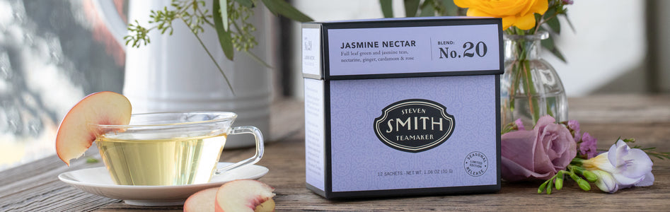 Box of Jasmine Nectar with a glass teacup filled with tea and a peach garnish.