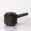 Black lidded teapot with spout and long handle.
