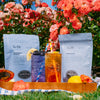 Two packages of Smith Tea with two iced teas on a wooden tray in a garden setting.