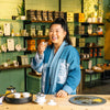 Chef Mei Lin smiling at camera while drinking tea.