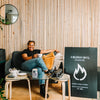 Candle maker smiling while drinking a cup of tea.