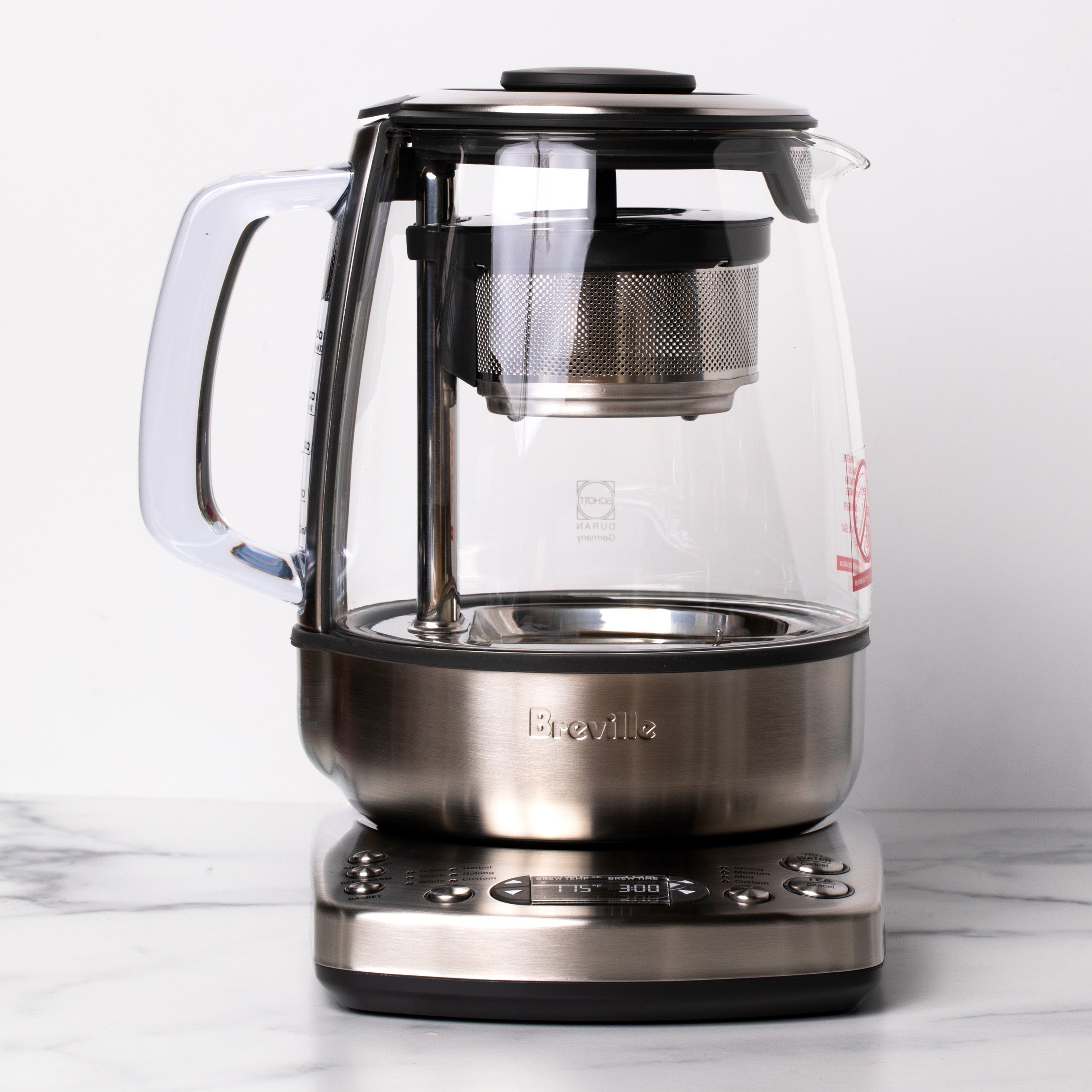 Clear electric kettle with silver handle and silver electric base.
