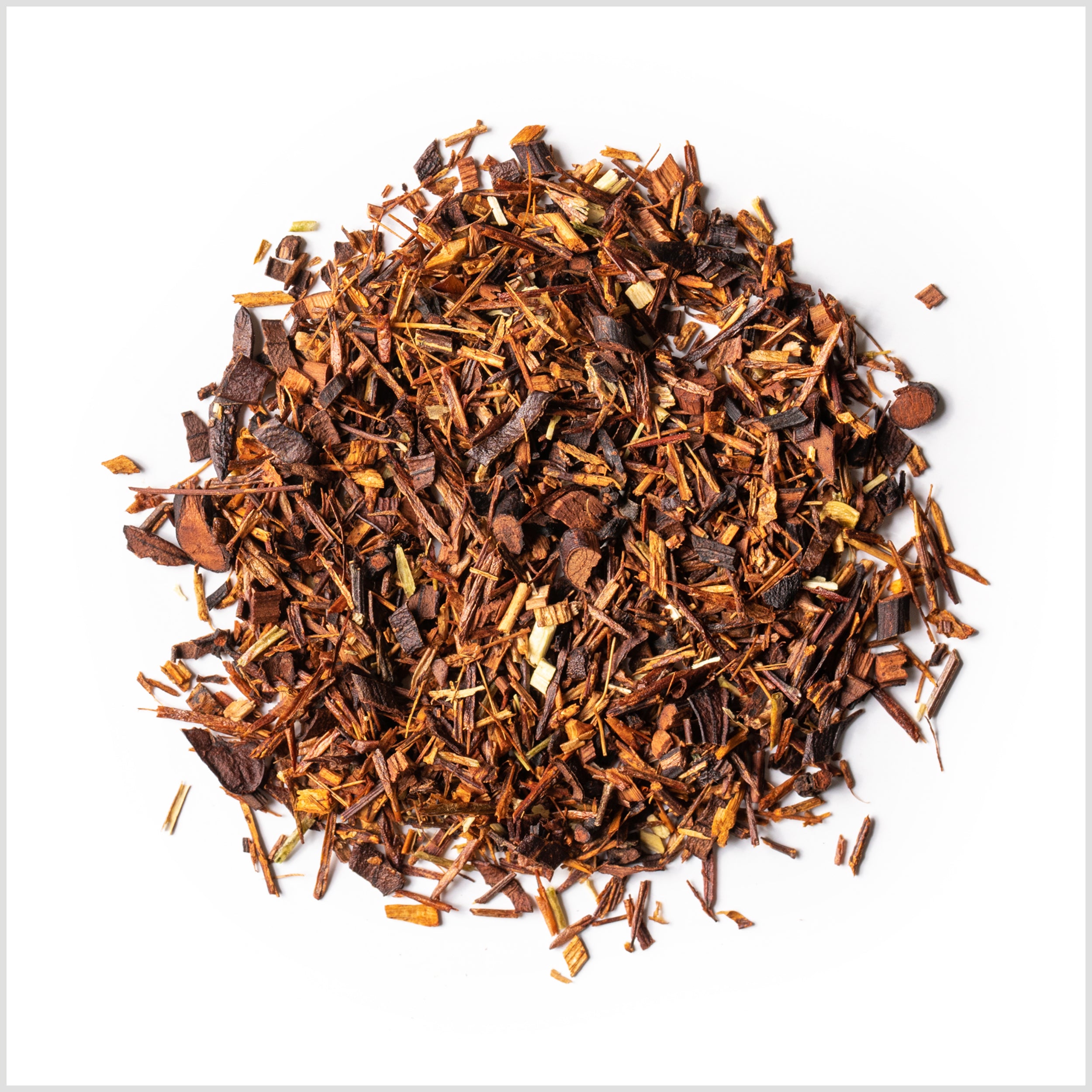 Circular pile of rooibos needles and honeybush on white background.