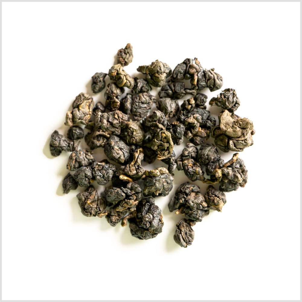 Circular pile featuring tightly wrapped nuggets of oolong tea.
