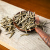 Wooden spoon filled with loose tea.