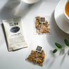 Three sachets of Golden Light tea on a marble table.